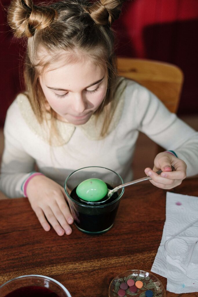 An image of a confident child and is experimenting with colored egg.