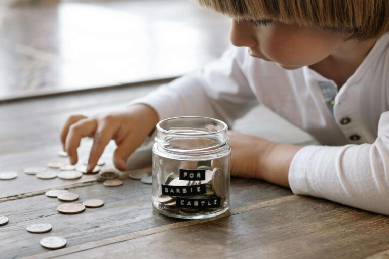 An image of a child counting coins. Saving is one of the good money making habits in kids.
