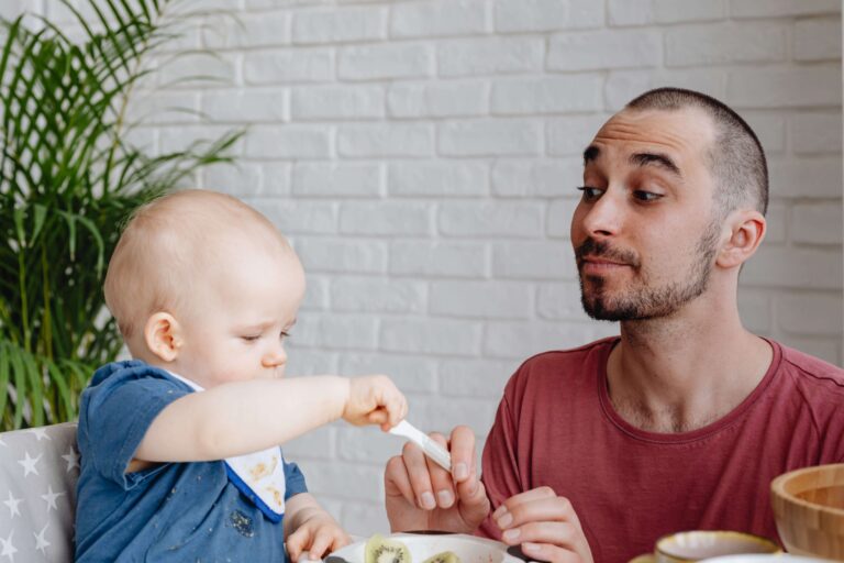 An image of a father and toddler learning table manners is an example of get kids to listen.