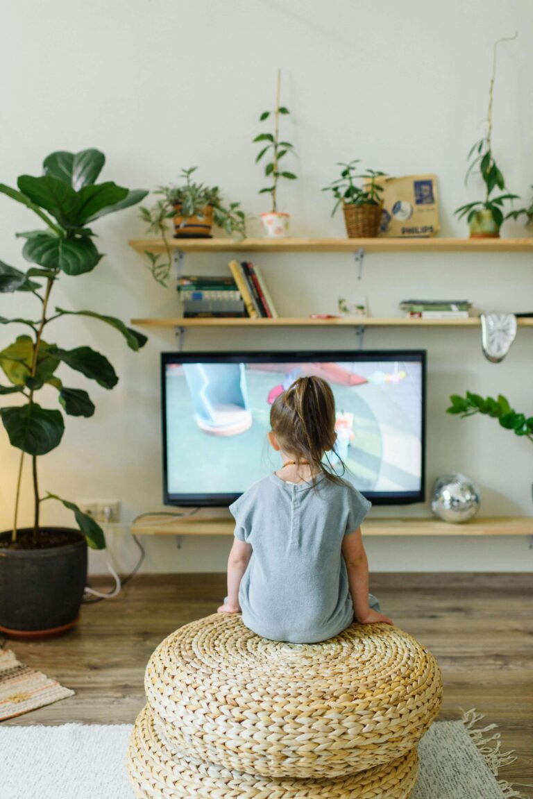 An image of a child watching tv. Limit Screen time is necessary step.