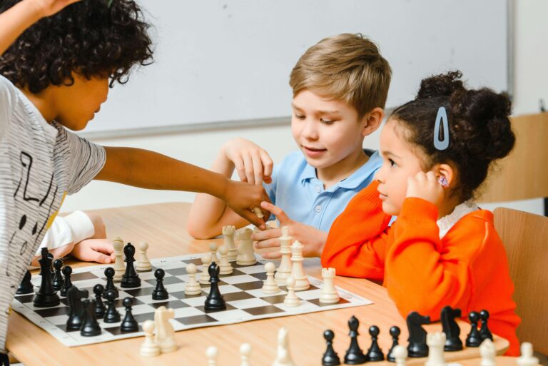 A group of children sits around a chessboard. This image highlights the importance of nurturing a child brain development through proper nutritional foods.