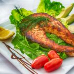 An image of a salmon fish plater with veggies. Salmon is best option for child brain foods.