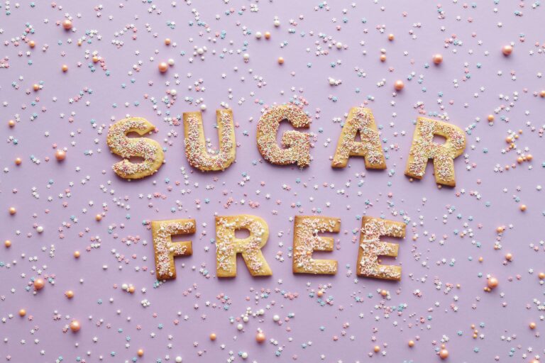 A close-up image of the words 'SUGAR FREE' written in bold, colorful font. This image highlights the importance of reducing a child's sugar intake for better health outcomes.