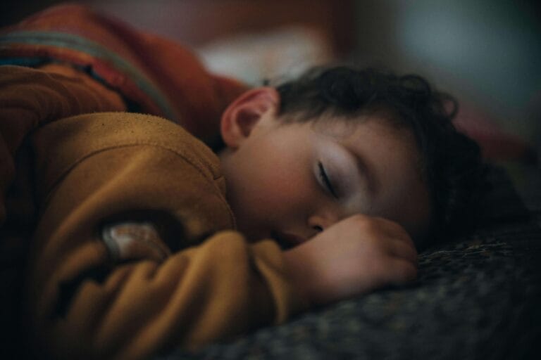 An image of a toddler that is sleeping in his crib without any fear and discomfort and it shows that he is not ready for the bed yet.