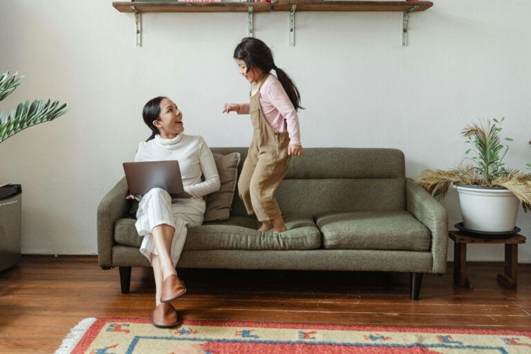 An image of an adhd child who is continuously jumping over the sofa and her mother is having no patience.