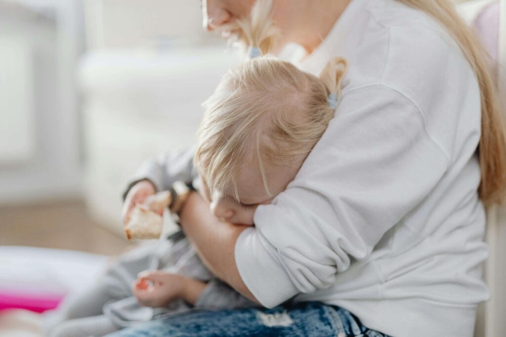 An image of an autistic child who sleeps and his mother trying to transfer him to bed.