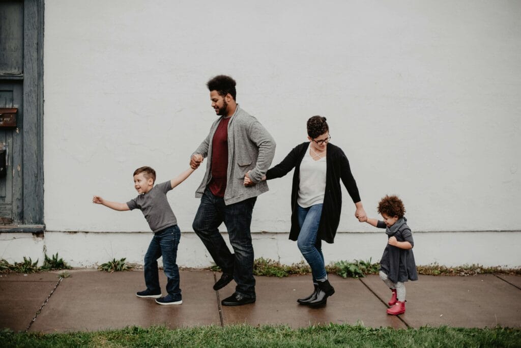 An image of a family of standing together and holding their hands with each other as a symbol of family bonding it looks they know parenting skills.